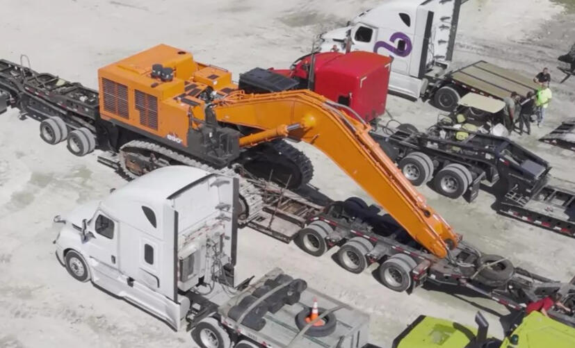 A large truck parked next to a large tractor in a parking lot. A big truck and tractor are side by side in a parking area. A large truck and tractor parked closely together.